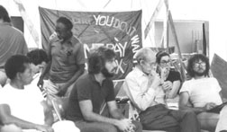 black and white photo of several attendees of the 1982 founding conference listening to a speaker