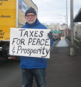 John Grueschow spreads the message of the Portland war tax redirection. 
